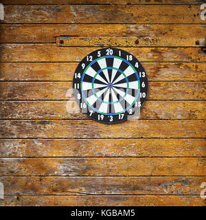Dart board on a wooden grunge wall Stock Photo