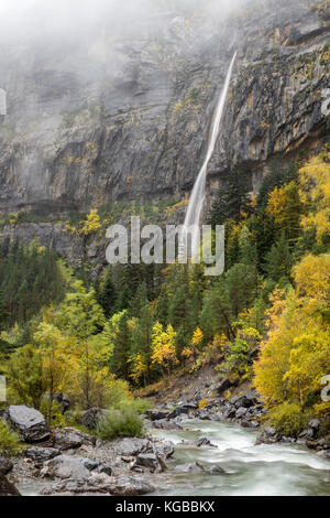 Waterfall, mountain, fog and river in autumn Stock Photo
