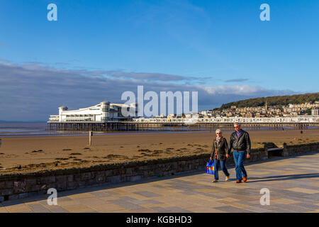 Healthy looking retired couple walking along the seafront promenade on a sunny November afternoon at Weston-Super-Mare, Somerset, Avon, England, UK. 06th Nov, 2017. Stock Photo