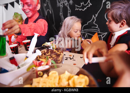Children sharing food at halloween party Stock Photo
