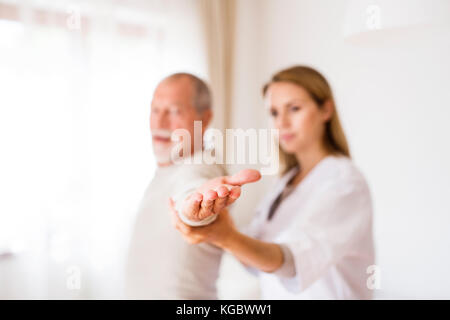 Health visitor and senior man during home visit. Stock Photo