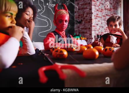 Boy in devil costume playing with  friends Stock Photo