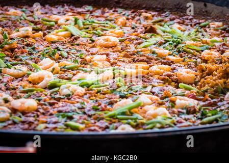 Paella dish with shrimp, closeup. Colorful Spanish paella rice in pan with vegetables and prawns. Stock Photo