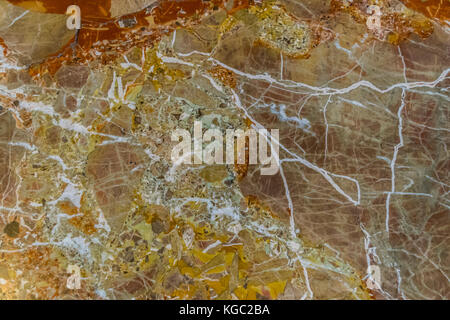 Marble background, yellow, red, white veins. Colorful abstract marble pattern closeup. Stock Photo