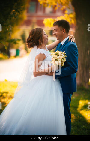 couple groom and bride against the background of orange leaves Stock Photo