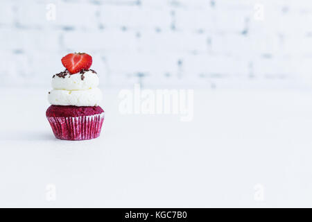 Red velvet capcake with mascarpone cream with strawberry. White background. Stock Photo