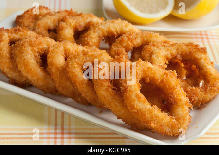Deep fried squid rings in Japanese breadcrumb and lemon Stock Photo