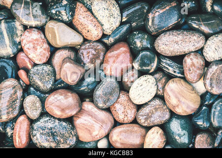 Colorful wet pebbles background with retro faded photo effect Stock Photo