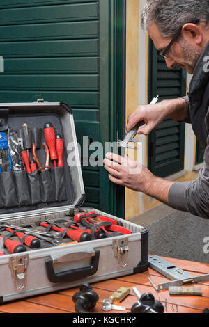 Locksmith repairing a door lock uses the gauge. Stock Photo