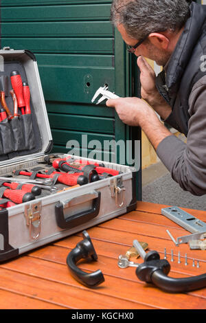 Locksmith repairing a door lock uses the gauge. Stock Photo