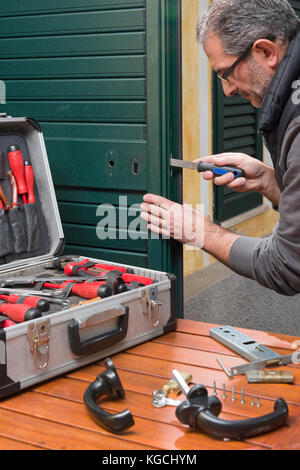 Locksmith repairing a door lock uses the rasp. Stock Photo