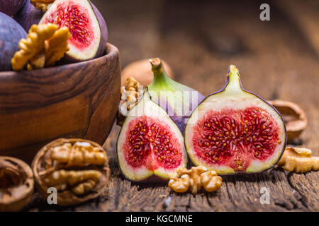 Figs and walnuts.. A few figs and walnuts in a bowl on an old wooden background. Stock Photo