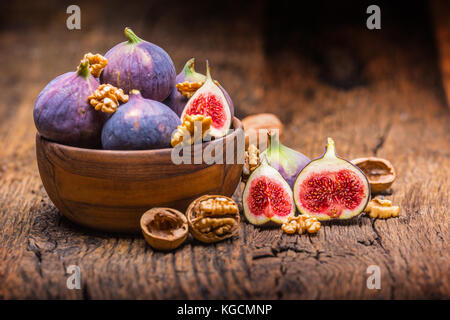 Figs and walnuts.. A few figs and walnuts in a bowl on an old wooden background. Stock Photo
