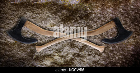 Two Ancient battle axes on old stone texture grunge Stock Photo