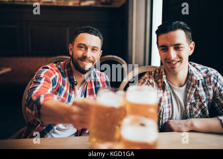 Hands Hold Beverage Beers Bottle Cheers in pub Stock Photo