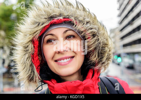 Attractive smiling woman in jacket with fur hood. Stock Photo