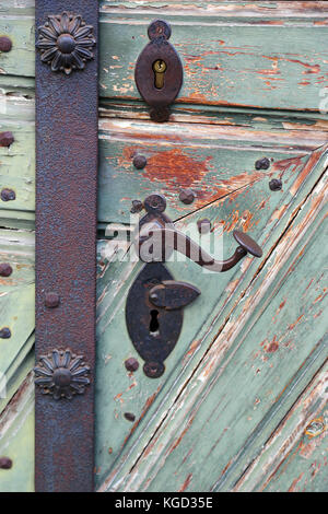 antique iron door handle on a wooden door Stock Photo