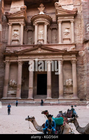 Pink carved sandstone, The Treasury, Al Khazneh, Petra, Jordan, Middle East, with camels and waiting camel driver Stock Photo