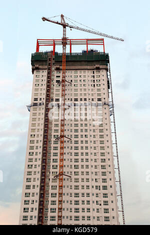 A highrise of apartment building being built with huge equipments Stock Photo