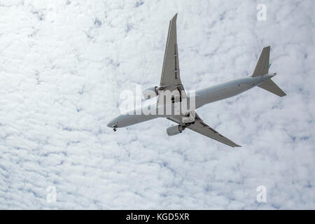 Commercial airliner flying overhead preparing for landing at LAX with brilliant clouds in the background Stock Photo