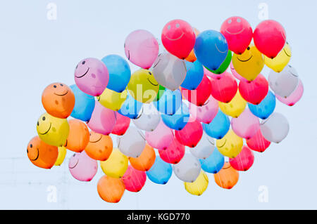 Bunch of vibrant color balloons with smiley face in the sky, Pune, Maharashtra Stock Photo