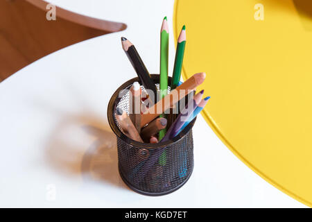 Crayons in a bowl . Color pencils for the drawing, located in a support as a vase . Multicolored pens Stock Photo