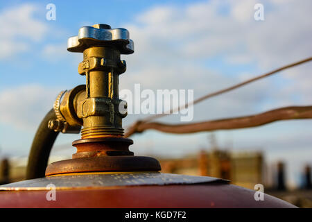 Close up image of an old gas cylinder valve with blue sky in background Stock Photo