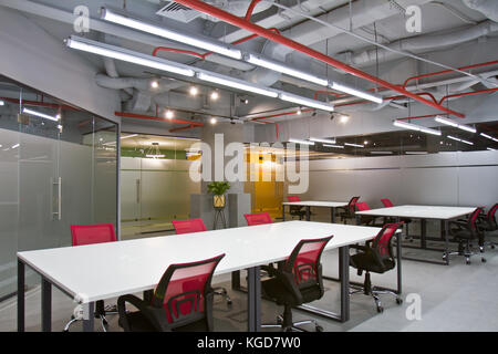 Luxurious office space with large white tables and chairs and modern design. Conference room interior with empty chairs and a projector screen. Stock Photo