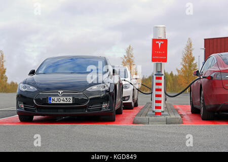 TOIJALA, FINLAND - OCTOBER 17, 2015: Three Tesla Model S cars are plugged in at Tesla Supercharger station. Supercharging is free for the life of Mode Stock Photo
