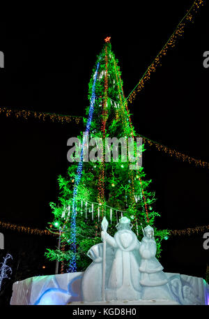 Illuminated christmas tree and ice sculptures of Grandfather Frost and Snow Maiden