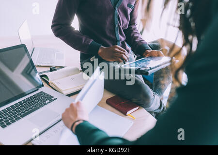 Middle section of contemporary multiethnic business people working together using multimedia devices like smart phone and tablet - working, business,  Stock Photo