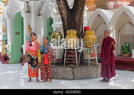 Burmese visitors and monk at the Shwedagon Pagoda / Golden Pagoda in Yangon, Myanmar in Yangon / Rangoon, Myanmar / Burma Stock Photo