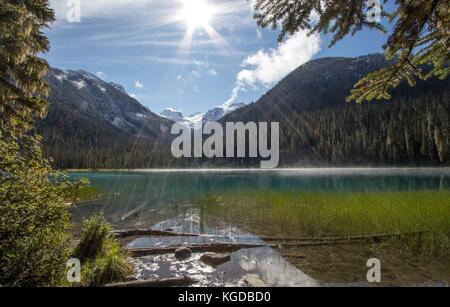 Lower Joffre Lake in British Columbia with mountain backdrop and sunshine Stock Photo