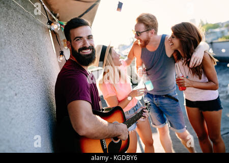 Group of happy friends having party on rooftop Stock Photo