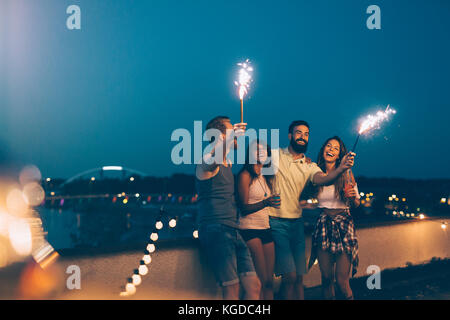 Group of happy friends celebrating at rooftop Stock Photo