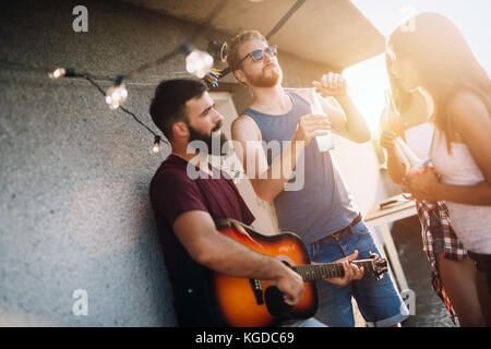 Group of happy friends having party on rooftop Stock Photo