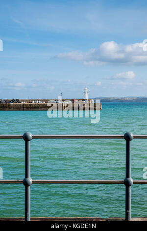 Metal railings protect pedestrians from falling into the sea at St Ives Harbour, St Ives, Cornall, UK Stock Photo