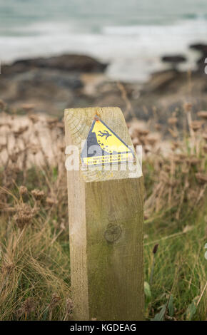 Unstable cliff edge sign warns against the danger of falling rocks and falling over the edge in Cornwall, England, UK Stock Photo