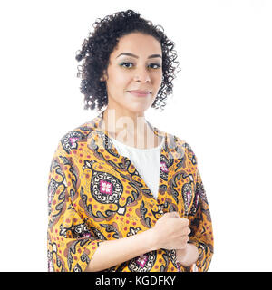 Girl poses for the portrait, her look is serious and confident. Short and curly haired woman wears yellow clothes and with floral pattern. Summer and  Stock Photo