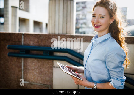 Portrait of businesswoman walking and holding tablet