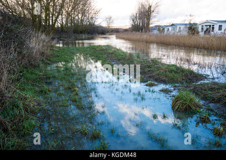 View of the Combe Haven river in its winter-flooded valley with footpath submerged. Stock Photo