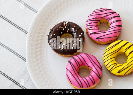 assorted donuts with chocolate frosted, pink glazed and sprinkles donuts Stock Photo