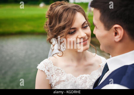 Young bride and groom smiling in nature near the lake