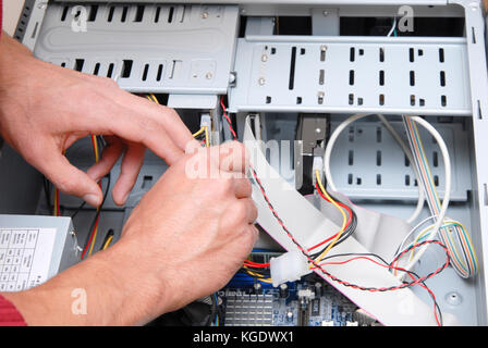 Male computer technician working on the inner parts of a PC Stock Photo