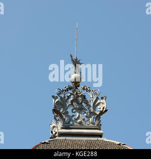 Close-up old weathercock of wrought iron on top of Margarida House constructed in 1905-1908 on Passeig de Gracia Street, 27 in bright sunlight on blue Stock Photo