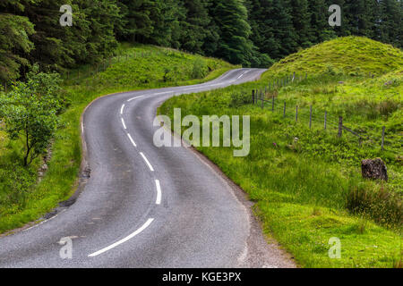 Curves on empty road in Scottish countryside under Ben Nevis peak, Great Britain. Cloudy summer day. Stock Photo