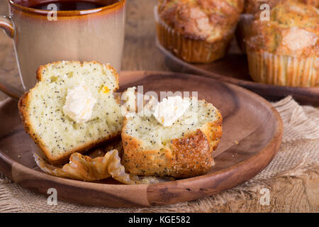 Lemon poppy seed muffins and cup of coffee on a wooden plate Stock Photo