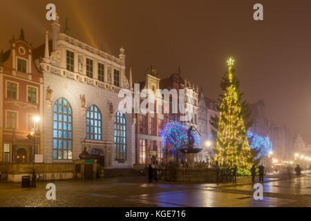 Historical Artus Court, fountain of the Neptune and Christmas tree in the centre of Gdańsk. Foggy night. Poland Stock Photo