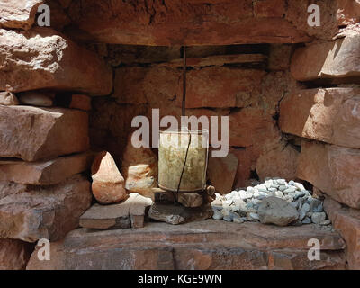 A small Buddhist prayer drum in a niche in the brown stone wall of a Tibetan monastery, China. Stock Photo