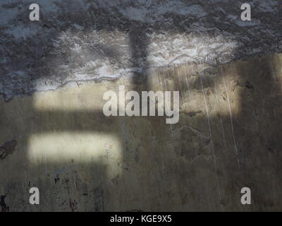 Sunlight falls through a window on the dark earth and create lighted squares, an abstract design texture. Stock Photo